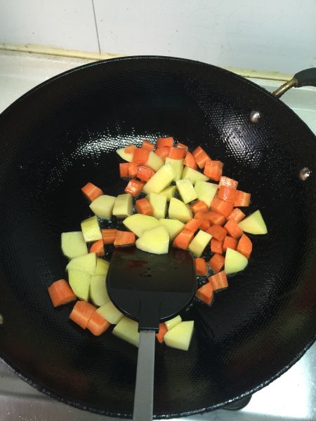 懒人版晚餐的做法操作步骤第3步：放入土豆块和胡萝卜块翻炒3分钟后加1勺盐继续翻炒2分钟。