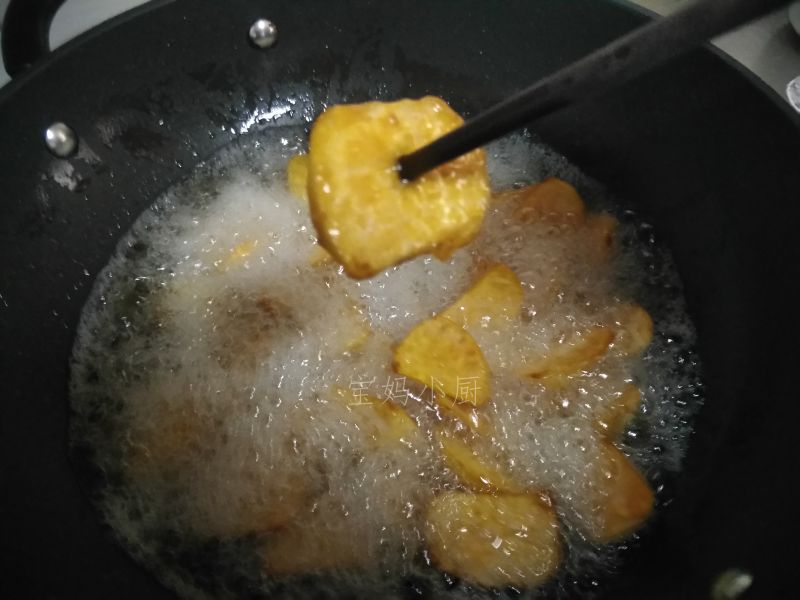 拔丝红薯的做法操作步骤第3步：锅内倒入炸油烧到四五成热放入红薯炸，期间勺子推动避免底部炸糊。炸到红薯外壳金黄微硬，用筷子能轻松扎透就可以了
