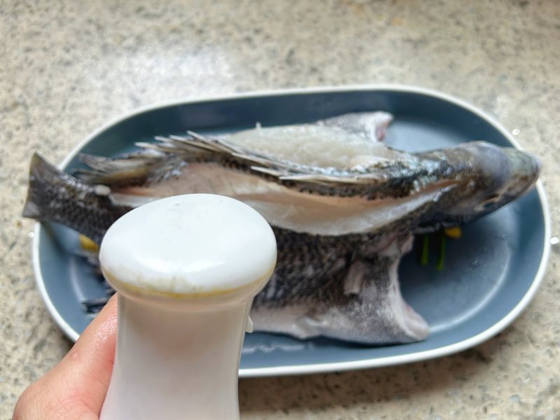 清蒸鱼的做法操作步骤第10步：腌制好的鱼沥干水分摆盘，然后表面喷点油