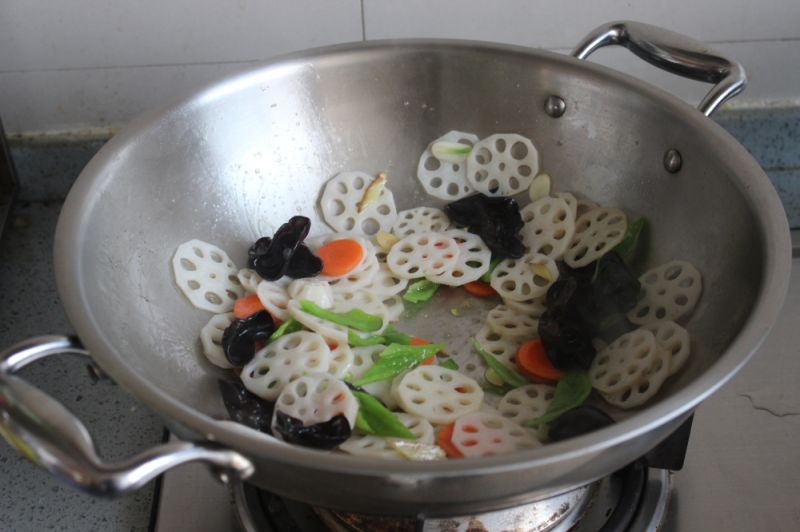 荷塘小炒的做法操作步骤第7步：加入藕、胡萝卜、木耳炒。