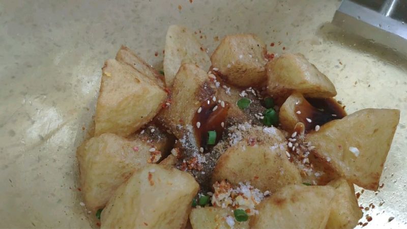 夜市超火小吃锅巴土豆的做法操作步骤第10步：撒点儿白芝麻、葱花，搅拌均匀