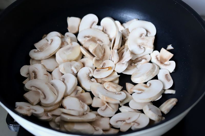 西兰花炒口蘑的做法操作步骤第7步：将口蘑放入锅中，中火煸炒，随着加热，口蘑会慢慢出来很多水分，将口蘑煸炒至变软。