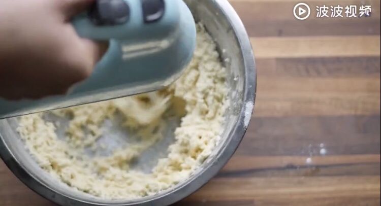 小高姐的葱香曲奇的做法操作步骤第2步：加入一半面粉，搅拌至无干粉状态后低速打发一分钟。加入剩下的面粉，重复以上步骤。