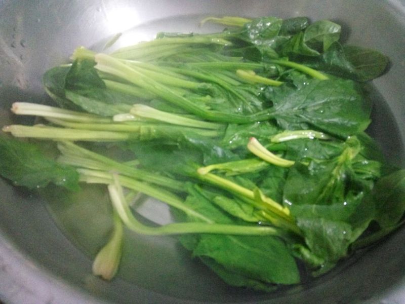 凉拌菠菜的做法操作步骤第2步：将刚烧开的热水倒入盆中，将菠菜烫透捞出，过一遍凉开水