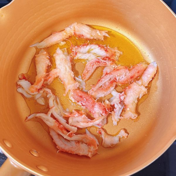 帝王蟹芝士烘蛋的做法操作步骤第8步：锅中倒入橄榄油，放入蟹肉煎至两面金黄。