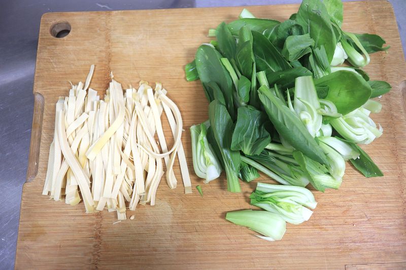 鸡腿焖饭香喷的做法操作步骤第16步：油菜清洗干净，豆腐皮切长约10公分长短的细丝；
