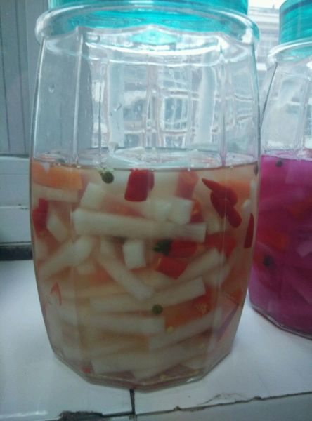 酸辣萝卜的做法操作步骤第4步：装入玻璃容器中，把晾凉的麻椒水加进去，水没过萝卜就好。盖上盖子隔天就可以吃了。时间越长越入味。