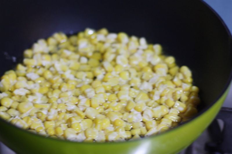 玉米烙的做法操作步骤第5步：平底锅烧热油，放入三分之一玉米粒，摊平，来回转动平底锅，把玉米粒煎熟，玉米烙就做好了。