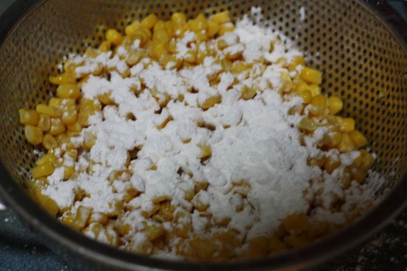 玉米烙的做法操作步骤第3步：将玉米淀粉和面粉倒入玉米粒。