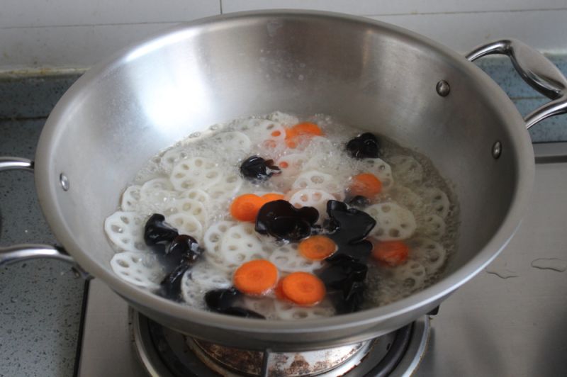 荷塘小炒的做法操作步骤第4步：锅中入水炒开，依次加入藕、胡萝卜、木耳焯烫到开捞出备用。