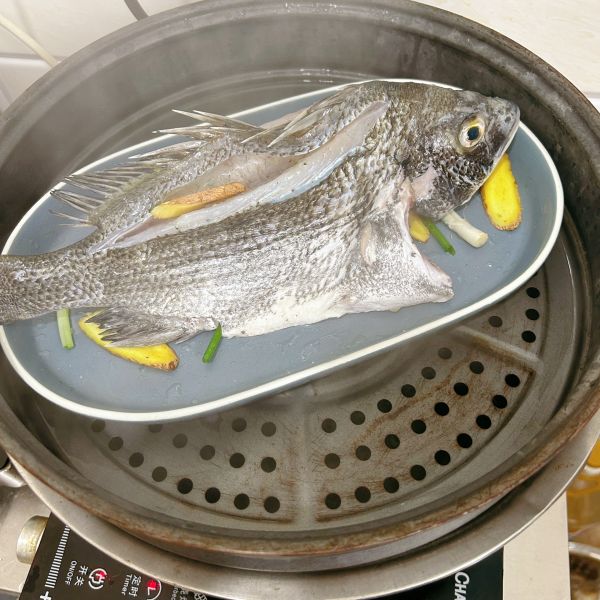 清蒸鱼的做法操作步骤第12步：水烧开，放入蒸锅里蒸15分钟左右（根据鱼的大小调整时间）
