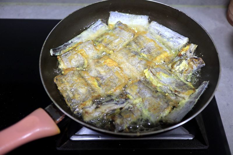 鸡腿焖饭香喷的做法操作步骤第9步：带鱼清理干净、切6公分左右的鱼段；蘸鸡蛋液入油锅小火煎至两面金黄；