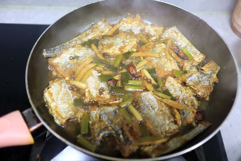 鸡腿焖饭香喷的做法操作步骤第11步：盖盖子小火焖炖，大部分汤汁被鱼段吸收即可出锅。