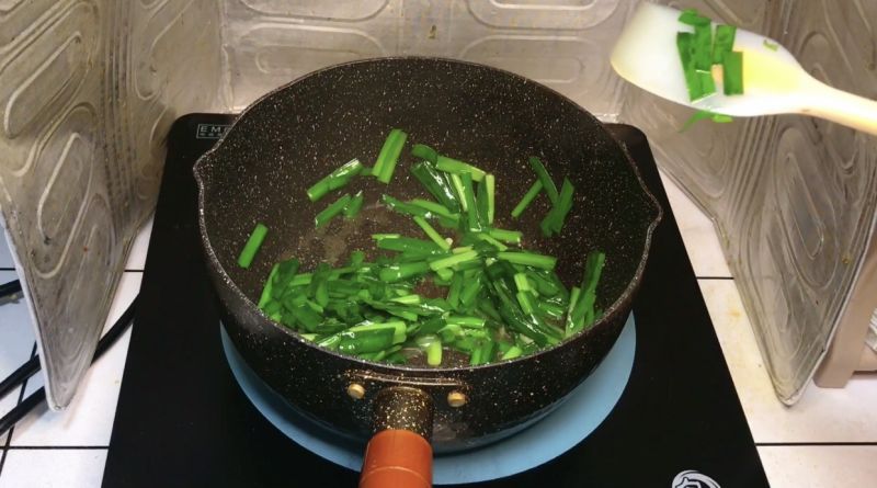 韭菜炒蛋的做法操作步骤第10步：热锅下油，加入蒜末和0.3克左右的盐翻炒出香味，倒入韭菜大火炒软后装盘