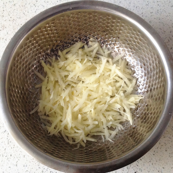 土豆丝软饼红豆粥的做法操作步骤第1步：土豆刮皮刨成细丝，用水冲洗控去水份后放入容器中。