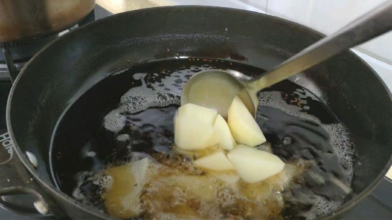 夜市超火小吃锅巴土豆的做法操作步骤第4步：土豆擦拭干净水分后，放入油锅中。