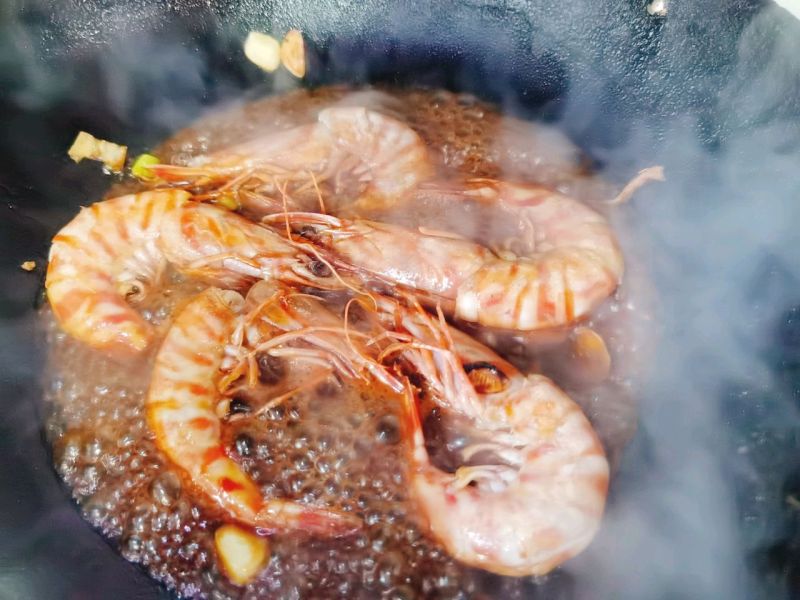 油焖大虾的做法操作步骤第5步：加入料汁，盖上锅盖焖3-5分钟。