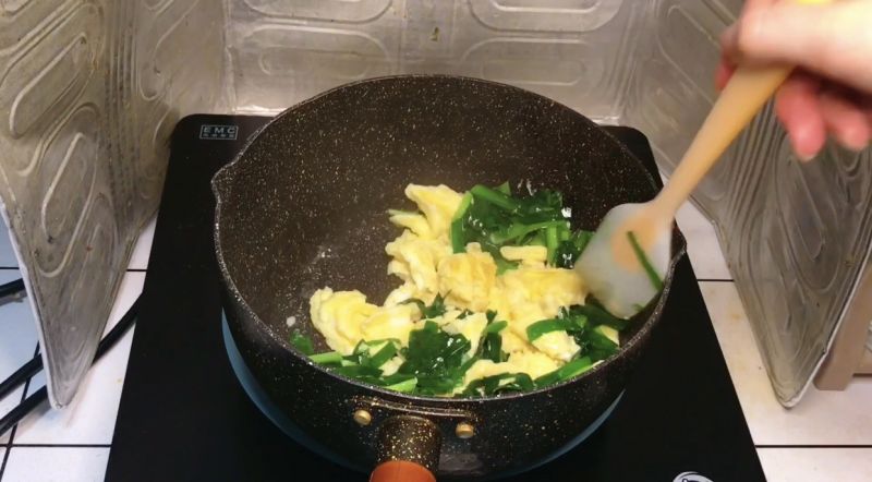 韭菜炒蛋的做法操作步骤第12步：然后倒入韭菜，用小铲子将鸡蛋分成小块，翻炒均匀就可以装盘出锅了