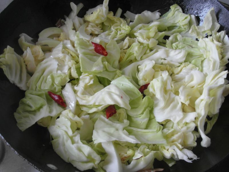 手撕包菜的做法操作步骤第3步：倒入包菜叶和辣椒翻炒
