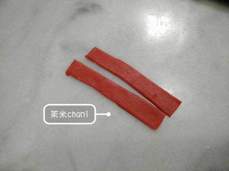 招财猫冰棍馒头的做法操作步骤第9步：接着把红面团擀薄，切出大约宽0.6cm，长6cm的宽条。