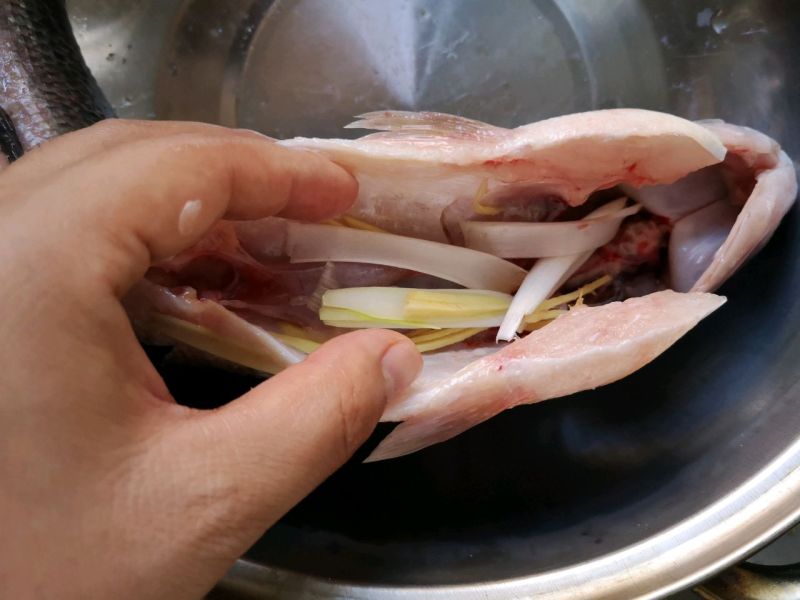 清蒸鲈鱼的做法操作步骤第2步：葱白切细片，姜切丝一部分塞鱼肚子内