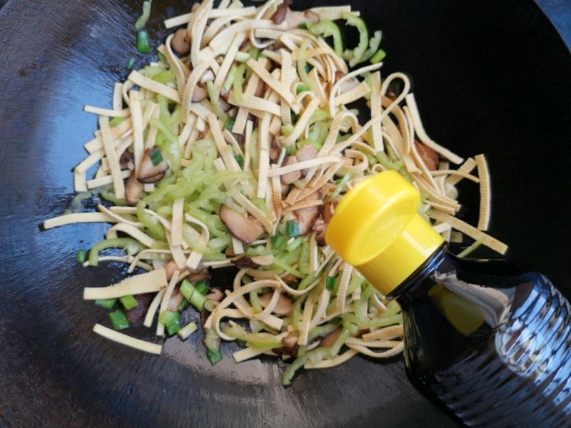 香菇尖椒炒豆皮的做法操作步骤第7步：加入生抽翻炒。