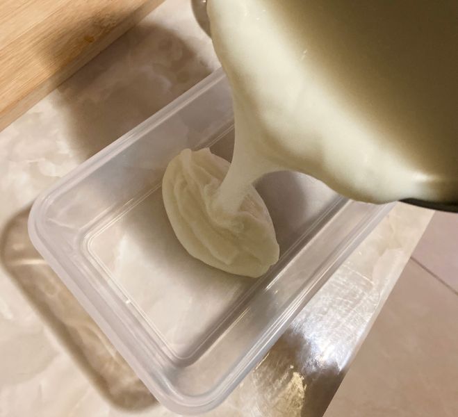 炸鲜奶的做法操作步骤第5步：然后把牛奶糊倒入长方形模具中，我用的保鲜盒，这种盒容易脱模