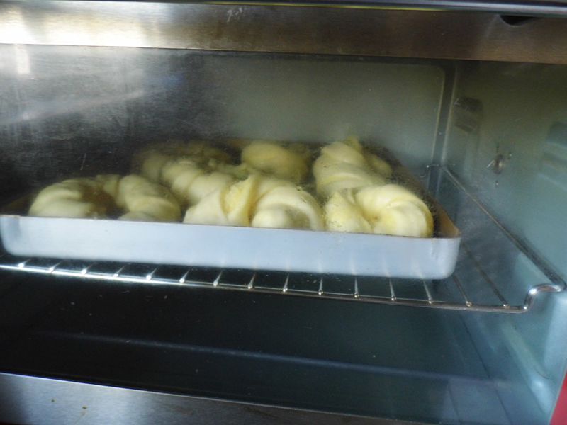 椰蓉面包的做法操作步骤第13步：烤箱180度，中层上下火15分钟至表面上色，捏面包两侧边快速回弹即可