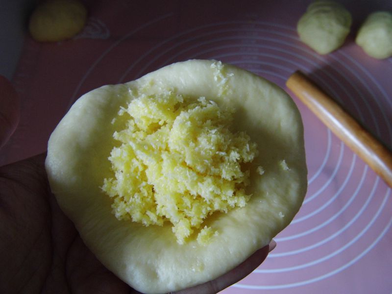 椰蓉面包的做法操作步骤第8步：然后把面团取出，分成八份（每个面团大约重60克），再滚圆，盖上保鲜膜松弛15分钟