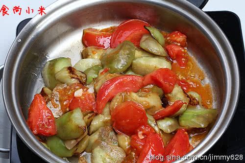 西红柿烧茄子的做法操作步骤第7步：先放入西红柿煸炒断生倒入生抽，老抽和白糖，再倒入茄子继续煸炒