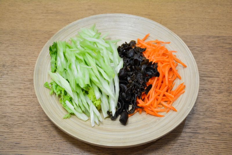 素炒三丝的做法操作步骤第2步：芹菜斜切粗丝，胡萝卜切丝或用擦丝器擦丝，木耳切几刀，由朵变丝