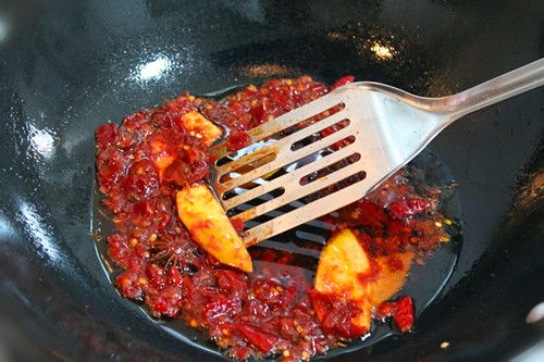 牛肉火锅的做法操作步骤第4步：锅内倒入10毫升食用油。油热后放入豆瓣酱、干红辣椒煸炒出红油，然后放放姜片、八角煸炒出香味。