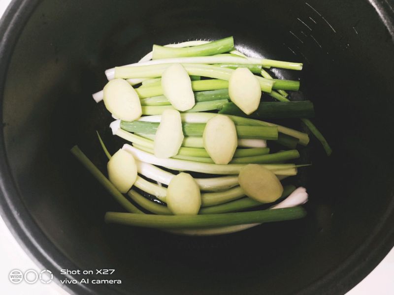 卤味拼盘的做法操作步骤第7步：/10.电饭煲中先铺入上小葱，再铺上姜片。