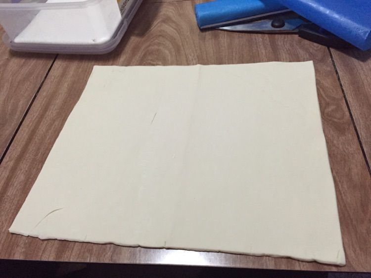 蝴蝶酥的做法操作步骤第1步：冷冻酥皮解冻后取出，平铺在桌面上，在边上轻轻按出四等分的标记