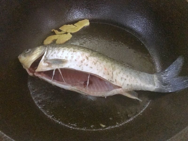 鲫鱼豆腐汤的做法操作步骤第3步：调中小火，把鲫鱼放入中小火慢煎。