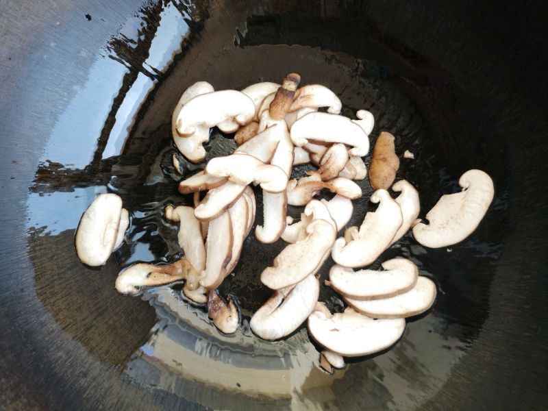 香菇尖椒炒豆皮的做法操作步骤第3步：锅中倒入油，加入香菇翻炒。