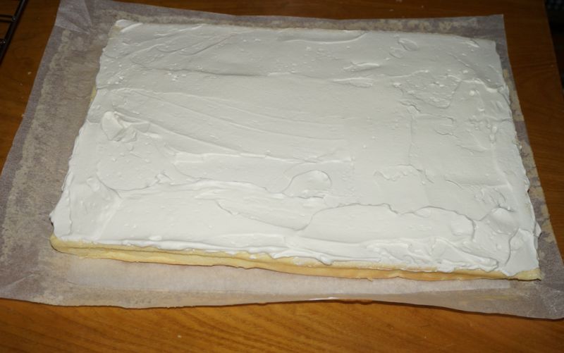 奶油戚风蛋糕卷的做法操作步骤第14步：将奶油均匀地铺平在蛋糕片上