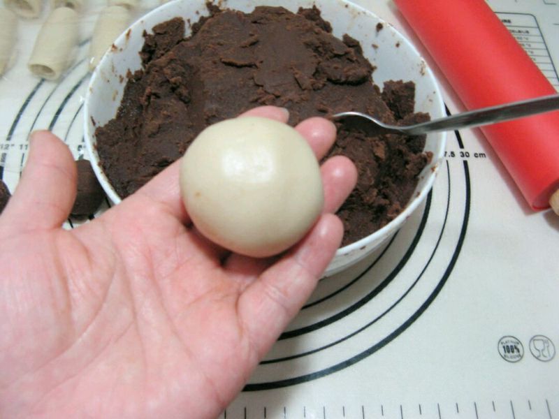 红豆沙印花酥皮的做法操作步骤第15步： 利用虎口将饼皮收圆，捏紧收口，略微整形，翻面成一个小圆球