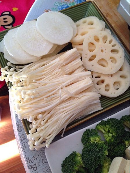火锅的做法操作步骤第3步：金针菇切掉根部洗净、大白萝卜去皮切片、莲藕去皮切片摆盘