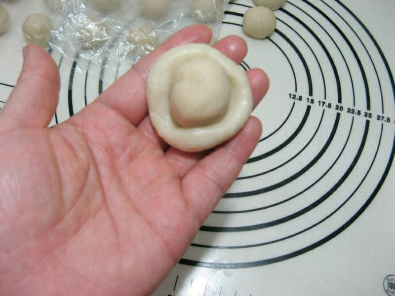 红豆沙印花酥皮的做法操作步骤第4步： 取一个油皮面团，按扁，再取一个油酥面团放在上面