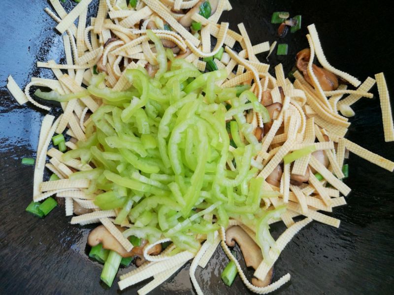 香菇尖椒炒豆皮的做法操作步骤第6步：加入豆皮和尖椒翻炒。