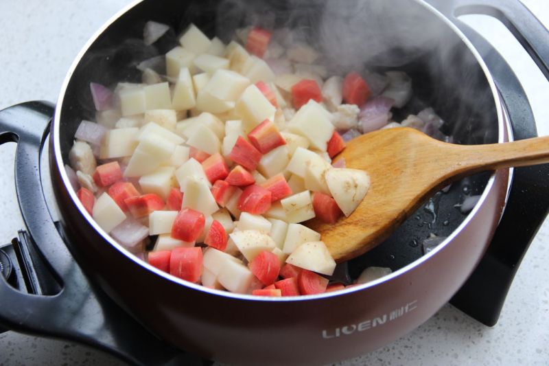 咖喱鸡肉饭的做法操作步骤第7步：待洋葱出香味后，加入土豆，胡萝卜，继续翻炒三分钟。