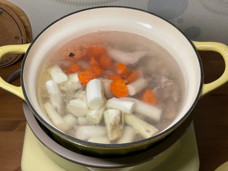 五指毛桃淮山鸡汤火锅的做法操作步骤第3步：鸡块、姜片、五指毛桃、淮山药、胡萝卜，倒进锅里，加入沸水，加盖煮20分钟左右。