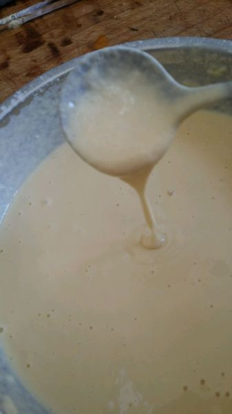 鸡蛋泡泡的做法操作步骤第2步：蛋液中加入适量40度左右温水，随后加入适量面粉，边加边用勺子搅拌，直至面糊可以拉丝