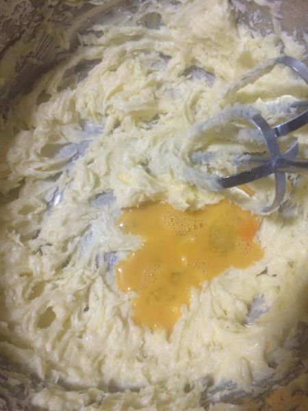 抹茶蔓越曲奇饼干的做法操作步骤第5步：用电动打蛋器打发到黄油颜色变浅蓬松状态，加入鸡蛋液，也可以分两次加入。