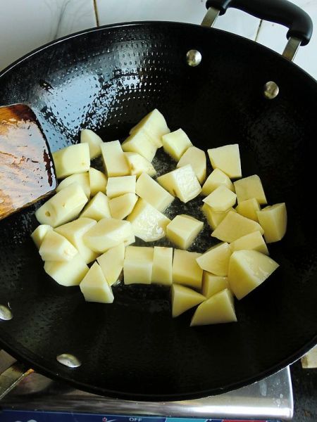 红烧土豆的做法操作步骤第3步：炒锅倒油烧热倒入土豆翻炒。