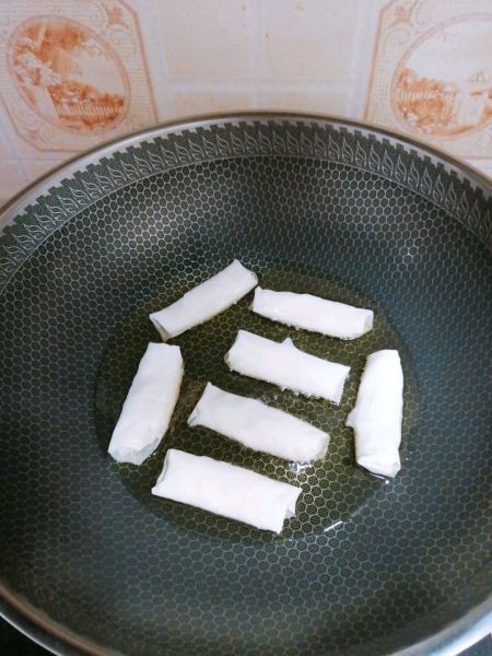 风味小吃素春卷的做法操作步骤第3步：锅里倒入玉米油后，小火慢煎，中途不停的用筷子翻面，直到春卷熟了为止！