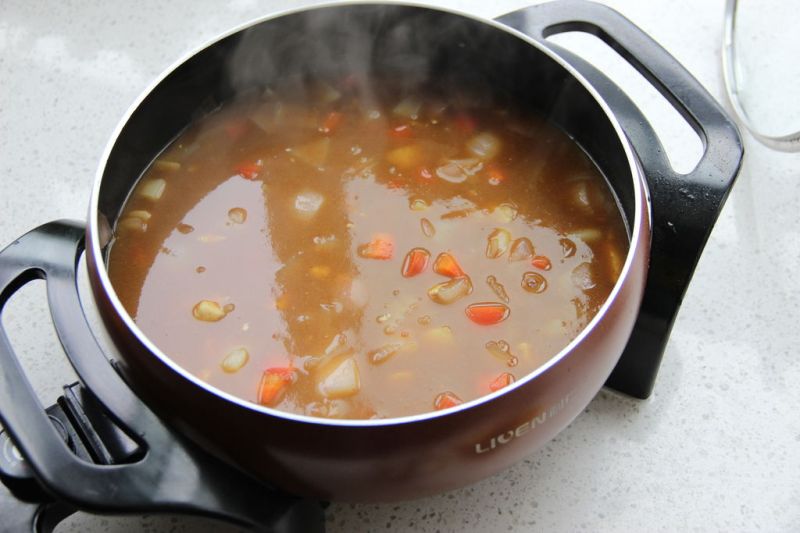 咖喱鸡肉饭的做法操作步骤第12步：此刻加入 青豆，玉米粒。小火，加盖，煮至所有食材软烂即可。根据自己的口味加入适量盐，黑胡椒碎。