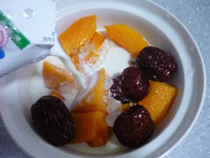 木瓜红枣炖牛奶的做法操作步骤第2步：把木瓜块、红枣、冰糖粒一起放到炖盅里，加入纯牛奶。