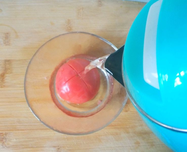 懒人开胃酸辣汤，西红柿的另类打开方式的做法操作步骤第2步：西红柿顶部划十字刀，浇热水泡一下，迅速冲凉水可轻松去皮。